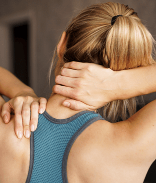 Woman dealing with neck pain, viewed from behind