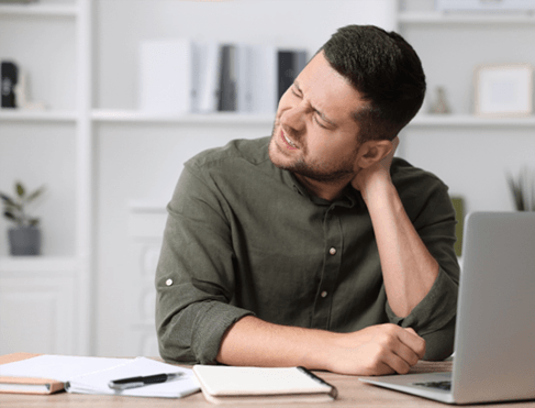 Man sitting at desk, suffering from neck pain