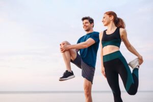 Couple exercising outdoors, performing stretches